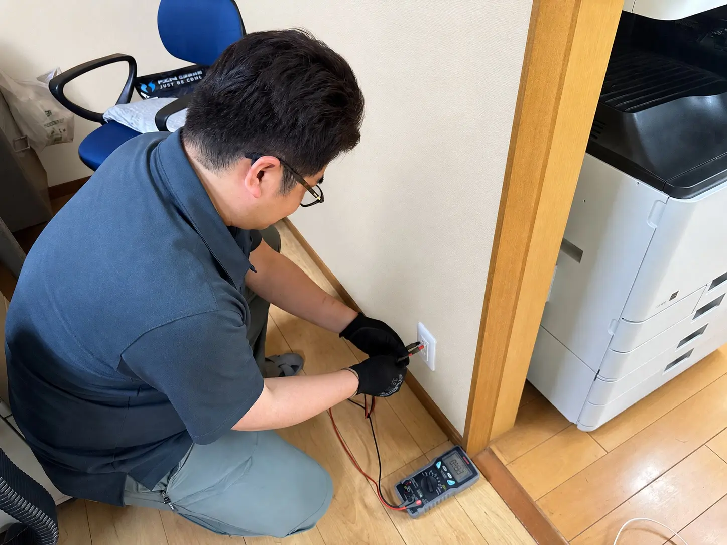 測定器を使ってコンセントを点検しているスタッフ